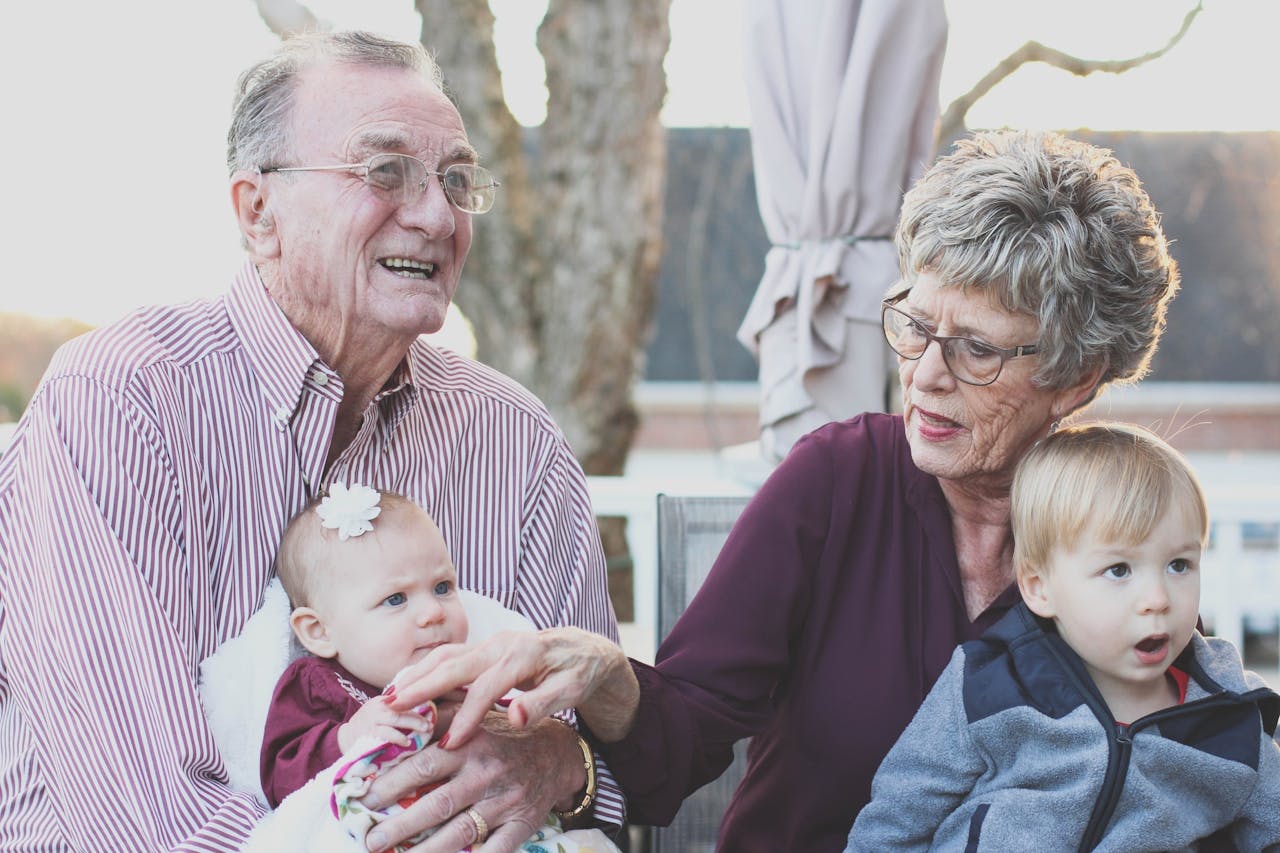 about-01 Grandparents spending joyful moments with their grandchildren in an outdoor setting, captured candidly.
