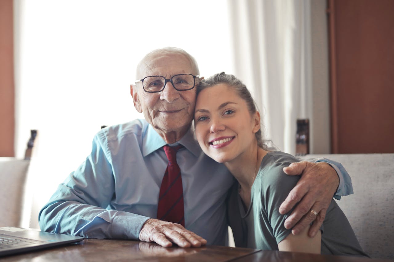 our-services-2 A joyful elderly man and young woman sharing an affectionate embrace indoors.